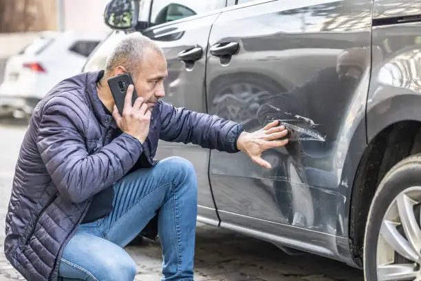 Client discutând la telefon detaliile finanțării pentru o mașină rulată