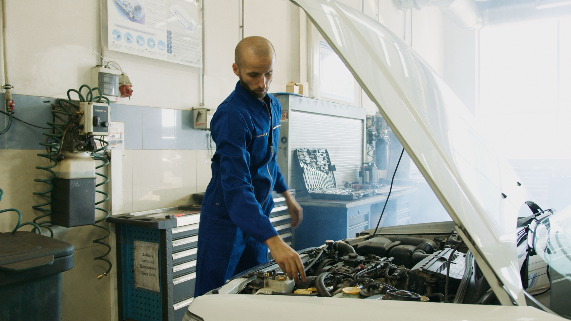 Mecanic Smart Auto Service verificand compartimentul motor al unei mașini în atelier